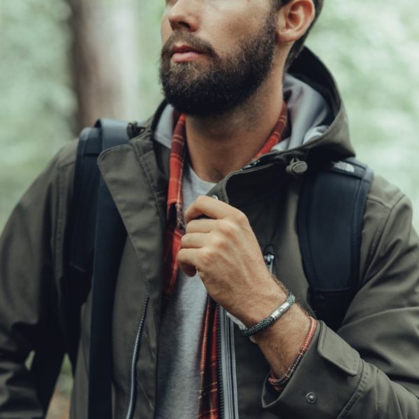 Man wearing grey and white rope bracelet outdoors