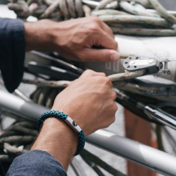 Man tying ropes with Boing bracelet