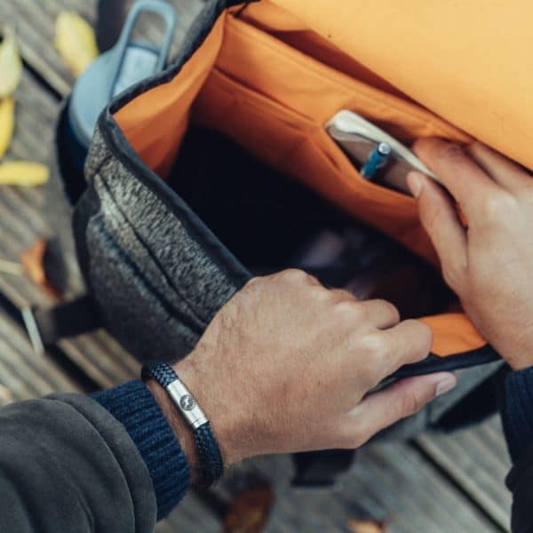 Man opening bag wearing climbing rope bracelet