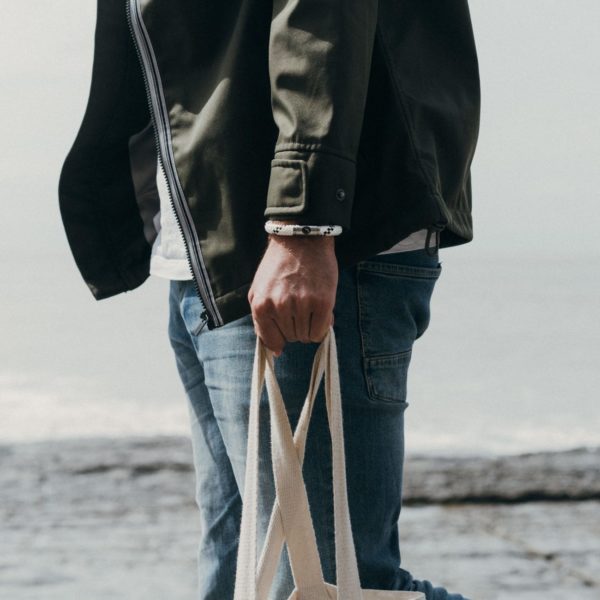 Man wearing white rope bracelet on beach