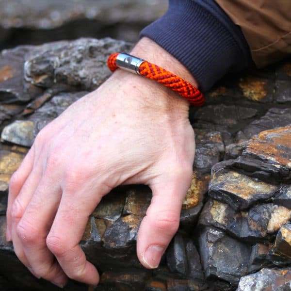 Rock climbing wearing a red rope bracelet