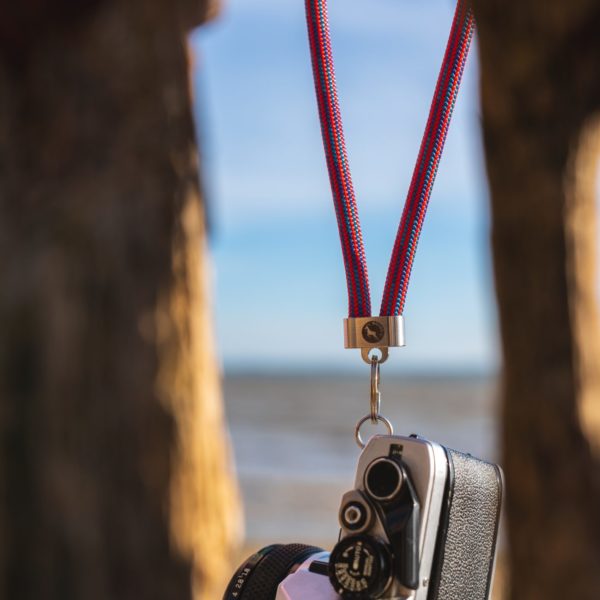 camera held up with red and blue steel key fob key ring