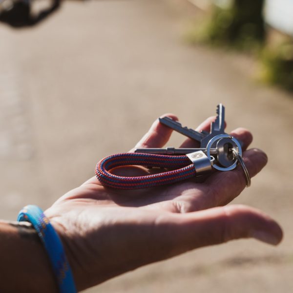 Hand holding speed red and blue key fob key ring