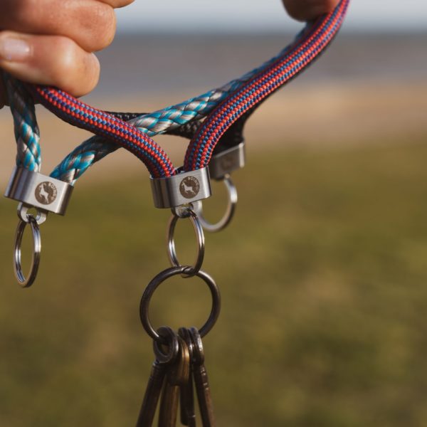 Man holding multiple rope key fobs outdoors